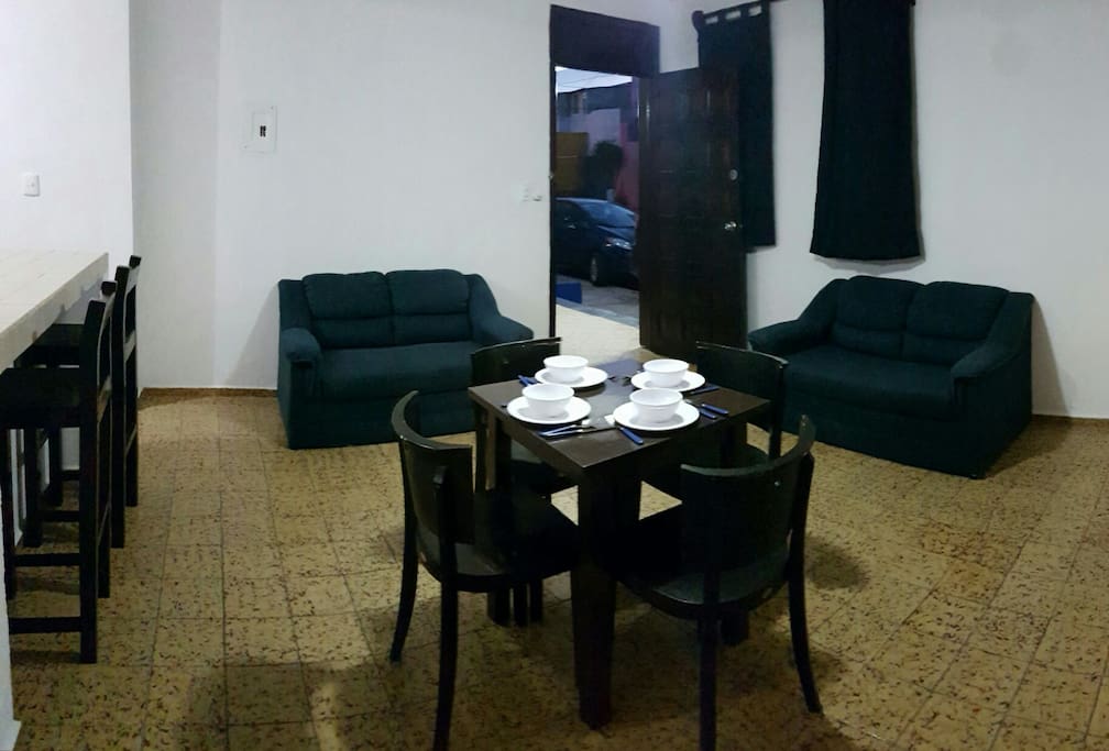 - Living & dining room: 2 couches, table with 4 chairs, ceiling fan.
- Sala Comedor: 2 sillones, mesa con 4 sillas, ventilador de techo.