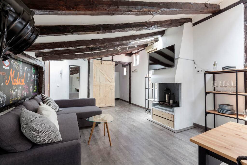 Chimenea decorativa, TV de 42 pulgadas. A la derecha menaje completo