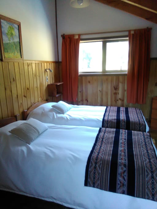 Habitación privada con camas individuales y baño.