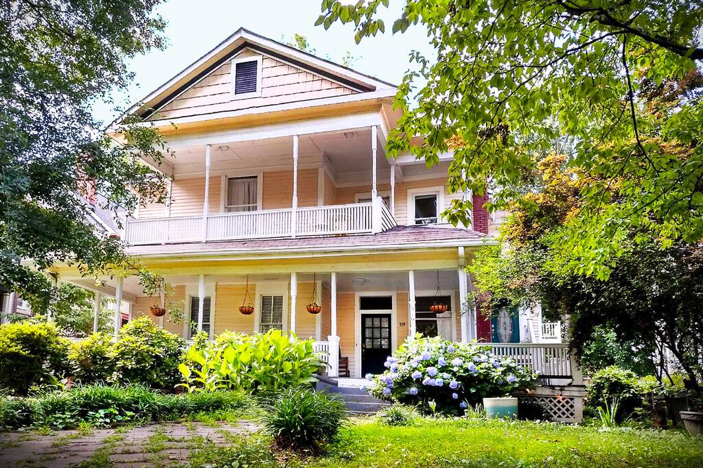 A very Southern historic home with wrap around porch and a giant oak tree. The house dates to the Victorian Period.