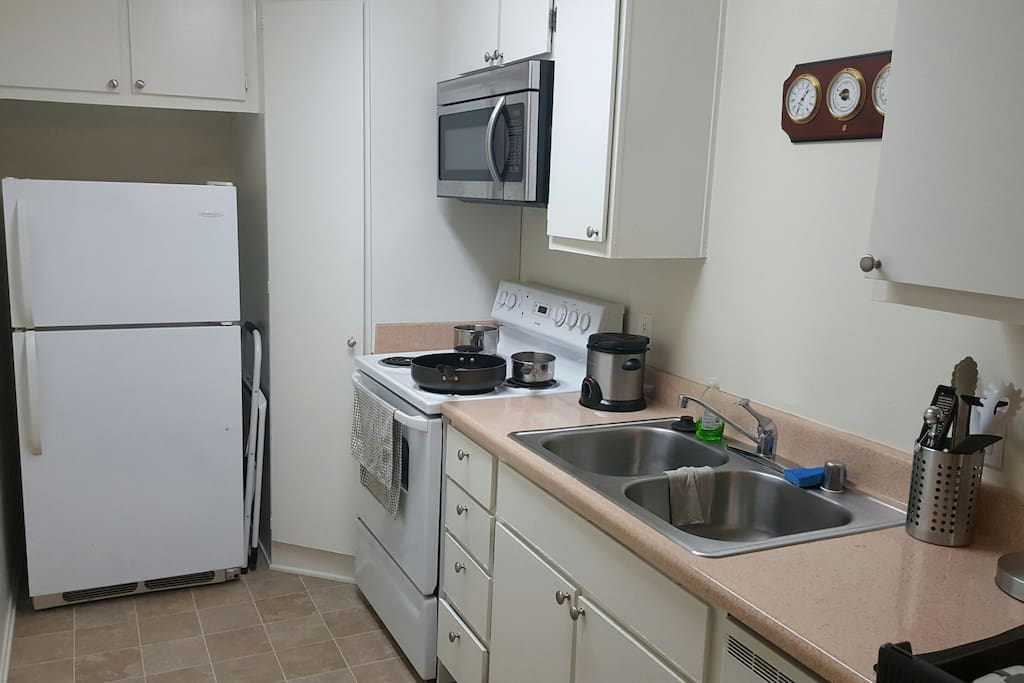 Fully supplied kitchen with electric stove, dishwasher, microwave and more.