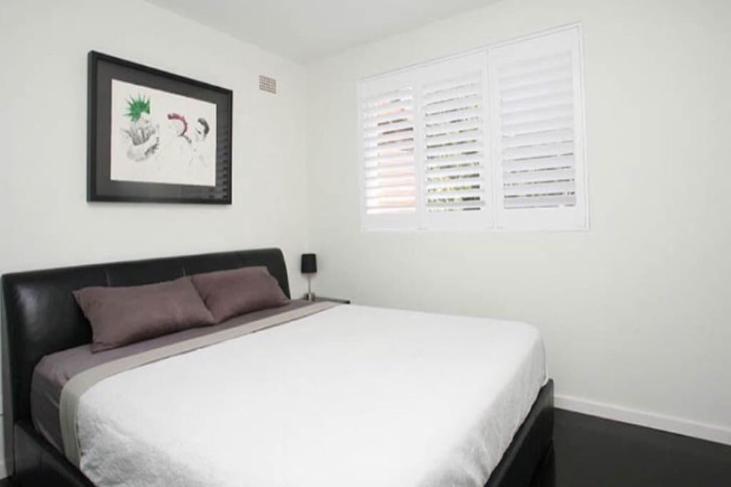 Double bedroom with large window and slide robes. The Modern look and feel runs throughout the apartment.