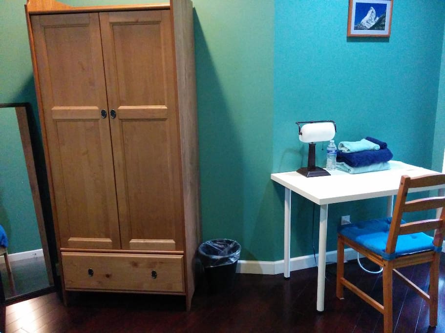 Bright desk by another window. Lamp, towels, and bottled water on your desk.