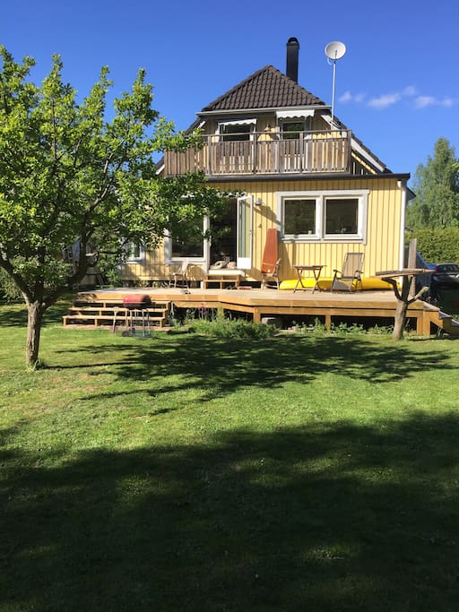 huset från baksida med trädgård och altan