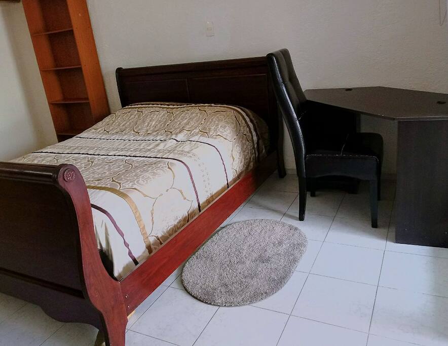 Cama matrimonial con un tapetito muy acolchonado y tu escritorio para trabajar un rato si lo requieres