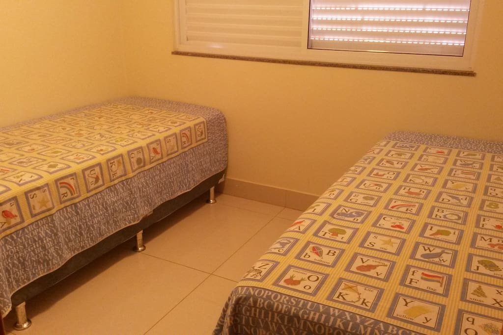 Quarto com duas camas de solteiro que podem ser juntadas e virar uma de casal.
