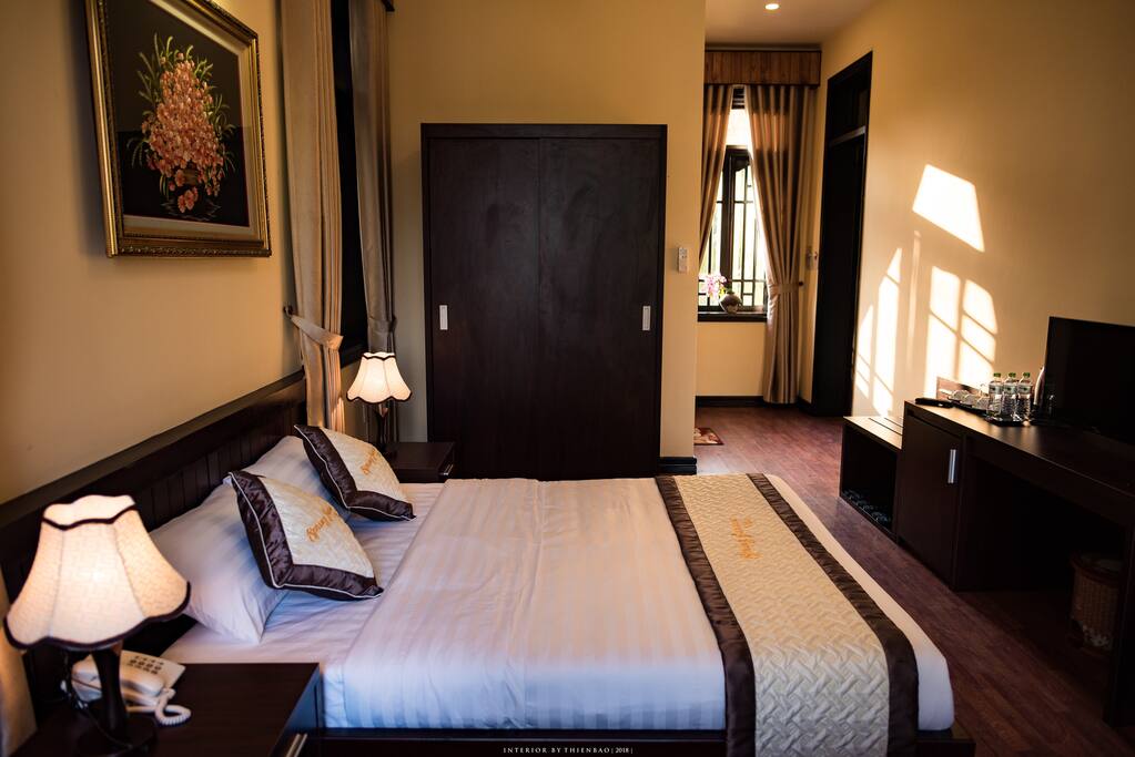 This bedroom has many windows with garden view, natural lights.