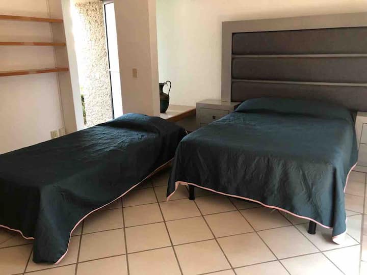 Cama matrimonial e individual en el bungalow.