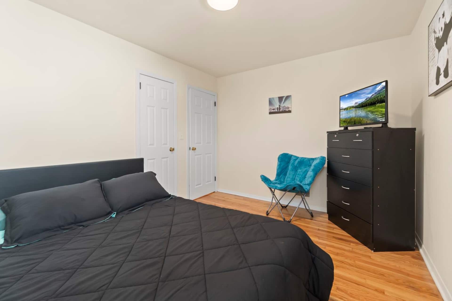 Segundo quarto com cama queen, sofá-cama e televisão