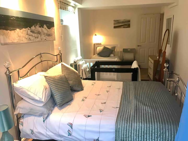 蓝色房间配有漂亮的全新双人床和单人床，如有需要，可提供旅行婴儿床的图片。 这间客房配有深色窗帘和法式门，可通往带甲板的庭院 