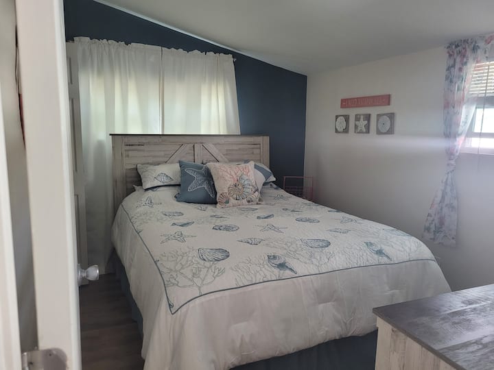 Segundo dormitorio con cama tamaño queen nueva y TV en la habitación.