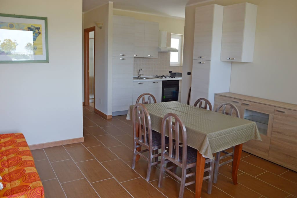 angolo cottura + sala da pranzo + tv + divano letto