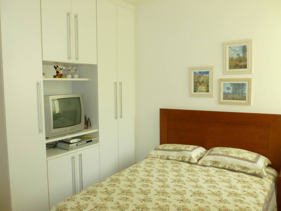 Suite com armário embutido, ar condicionado e TV.