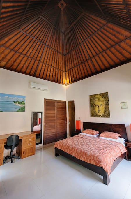 Balinese style bedroom with high ceiling.