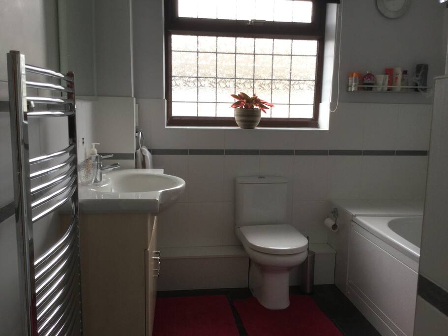 Bathroom with basin, toilet and bath with a shower over the bath. Guests may be sharing with other guests if the single room is also occupied.