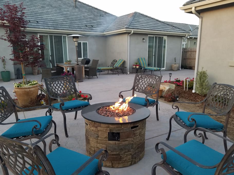Outdoor terrace with several seating areas for dining and a fire pit for evening socializing