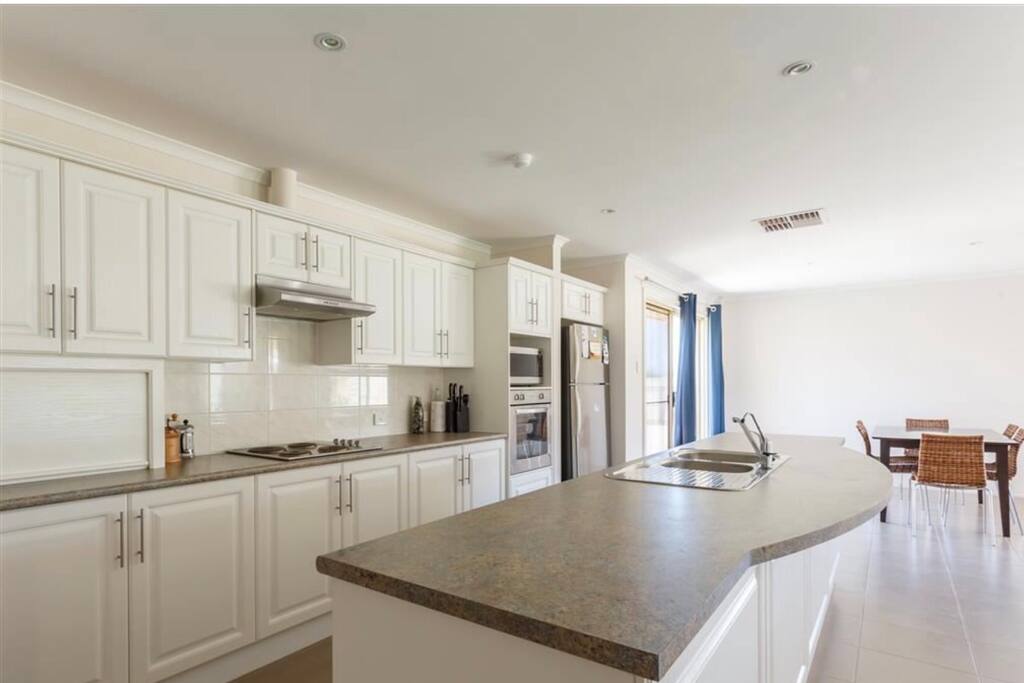 Kitchen - tea, sugar and pod coffee machine. Pura tap. Dining table seating up to eight. Two stools at bench. Provides for up to ten guests.