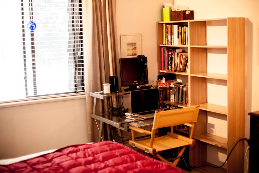 bookshelves and desk with big bright window with view of Lion's Gate bridge