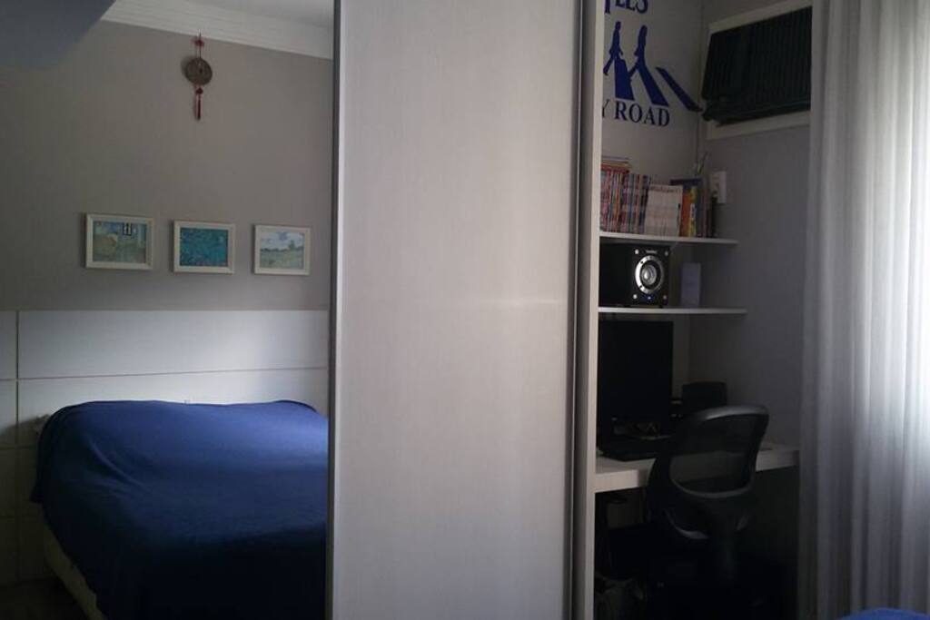 um dos quartos com armário e área de trabalho