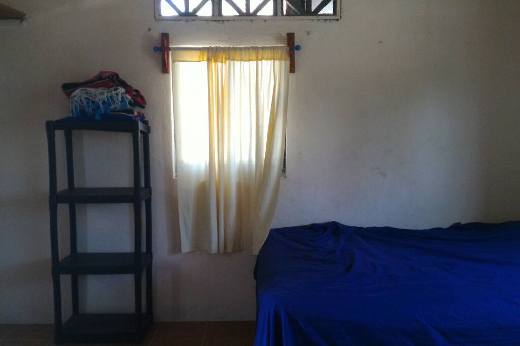 To the left of the door. more shelves and a rod to hang clothes behind the door.