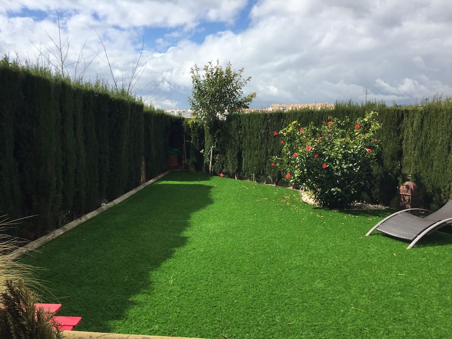 Jardin clôturé et privé, pelouse synthétique toujours verte, avec transats