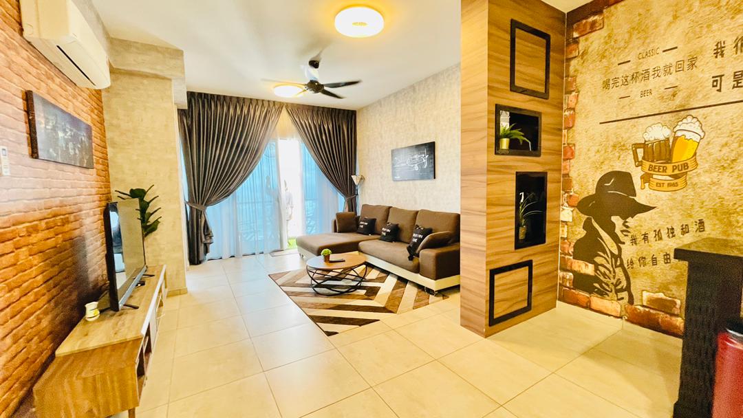 A spacious living room features a brown sofa set paired with a circular coffee table, situated on a patterned rug. Large windows are dressed with dark curtains, allowing natural light to fill the room. A flat-screen TV is mounted on a wooden console against a textured wall.