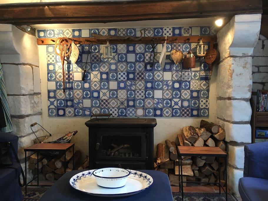 The woodturning stove in a huge inglenook with local blue and white tiles.