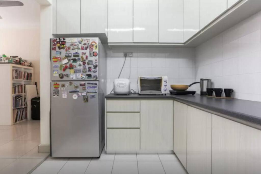 Kitchen with fridge, rice cooker, oven, induction cooker and frying pan.