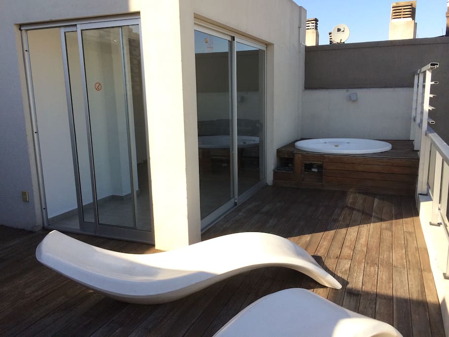 Espacio compartido en la terraza con parrilla, reposeras y Jacuzzi.