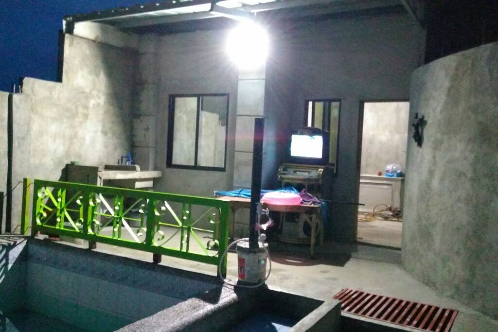 beside the pool is a videoke machine.