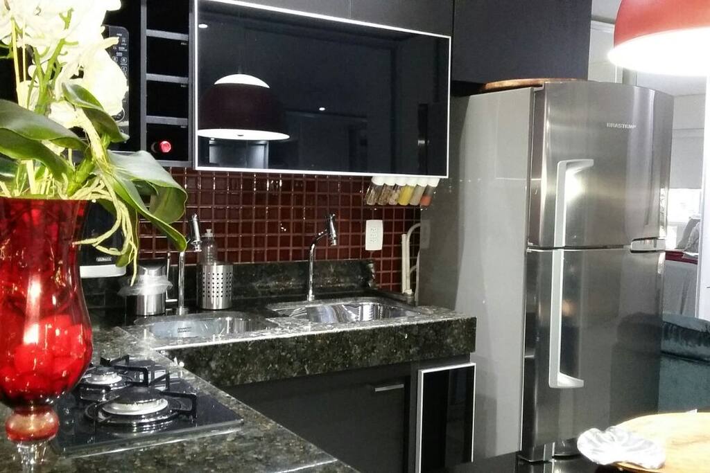 Agradável cozinha equipada com geladeira, microondas, cooktop, purificador de água com opção de água gelada e natural, duas cubas e utensílios de cozinha