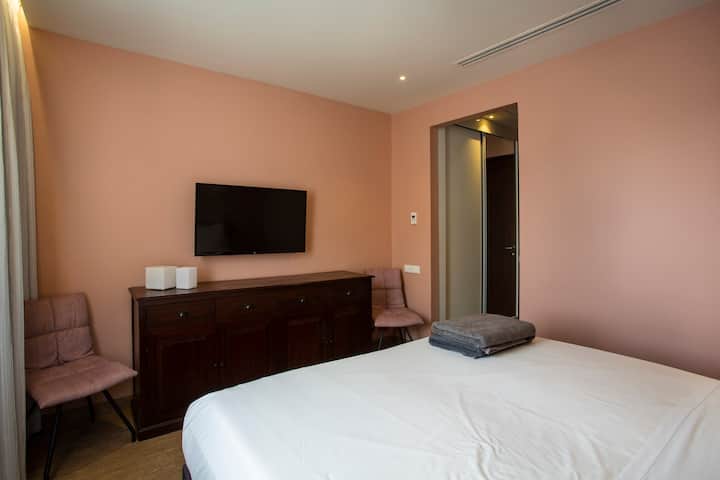 Dormitorio 2 con TV y baño contiguo.