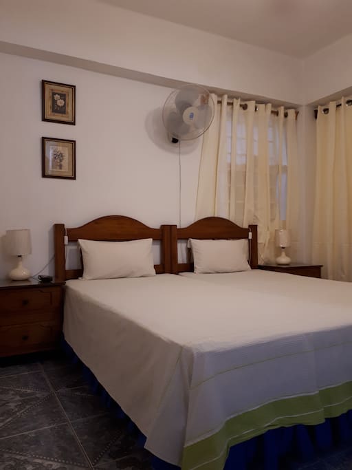 The bedroom (equipped with two single beds that can be placed together for couples, or separated). The room has AC!