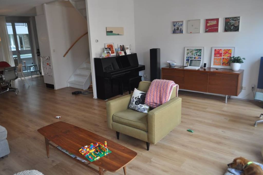 Spacious living room with comfortable couch, piano, stereo and television.