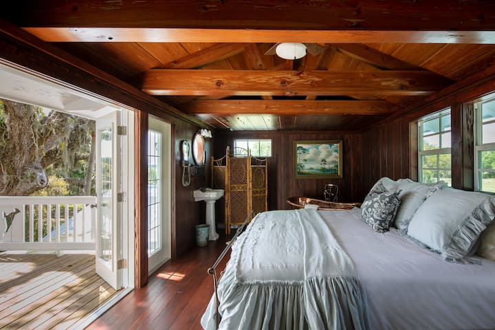 Upstairs bedroom with outdoor balcony overlooking the river. King bed