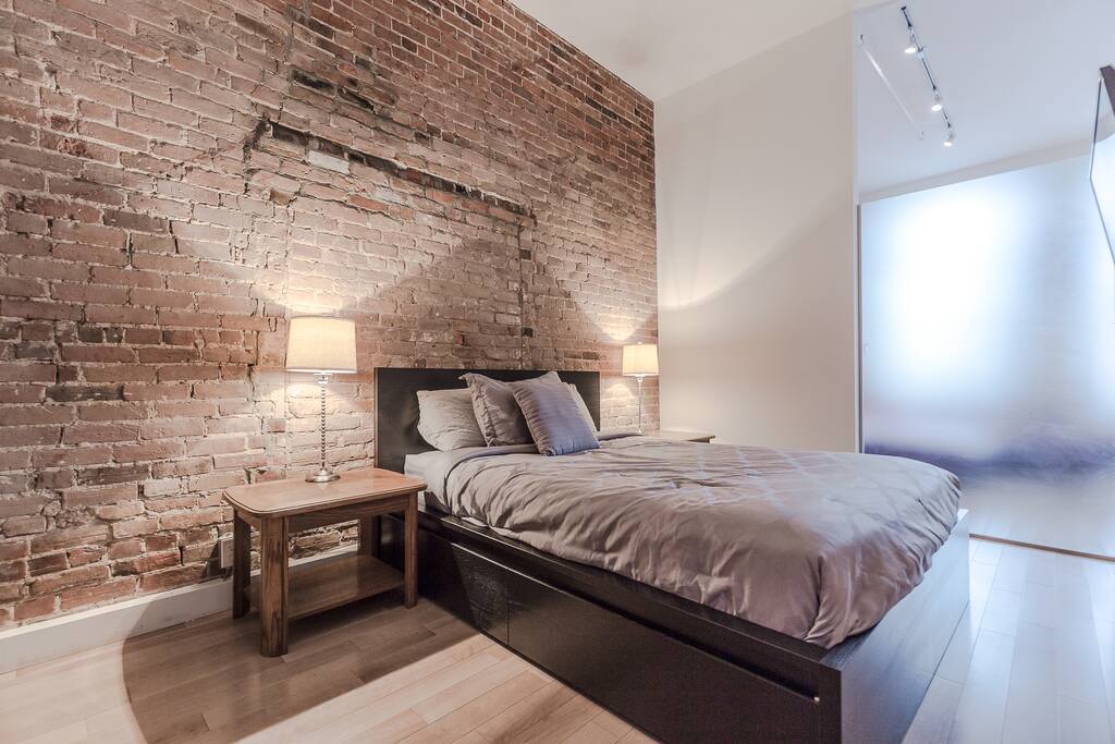 Stunning queen-size bedroom with brick wall