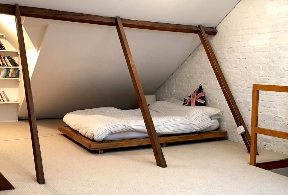 The main Bedroom is a beautiful loft space with lots of natural wooden features
