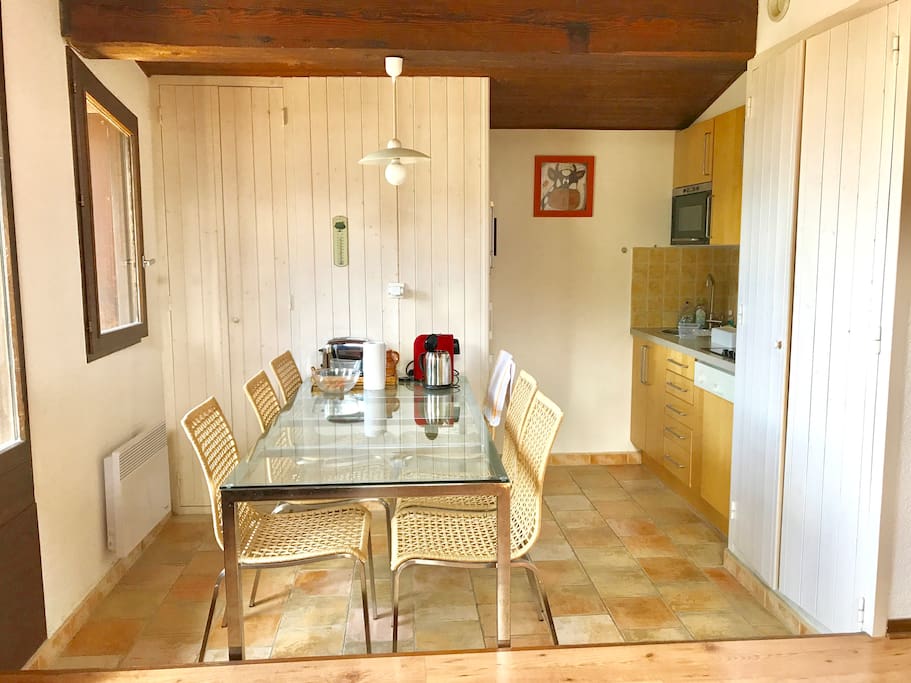 La grande table de la salle à manger et la cuisine à droite