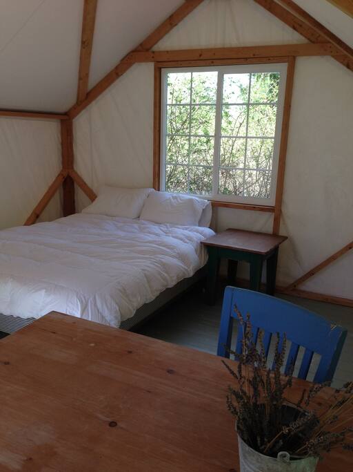 Queen bed on box spring with cotton sheets, down comforter and blankets.
