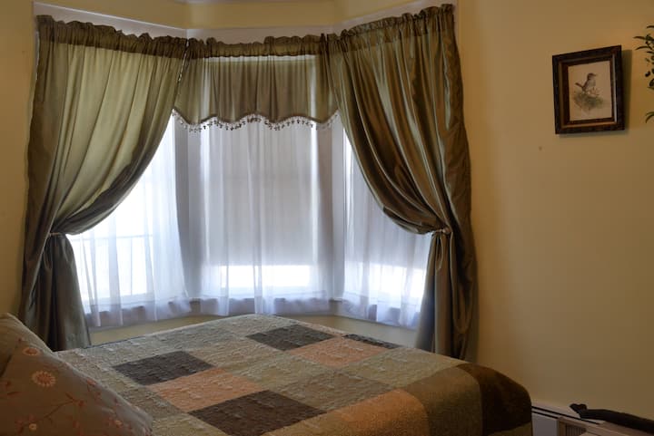 Laurel Hill Creek Bedroom with queen bed, AC window unit, ceiling fan, and private bathroom. 