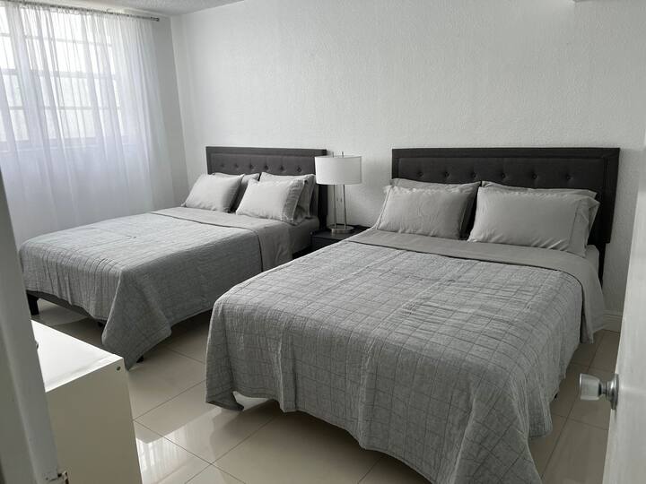 Relax in the inviting Guest Bedroom, complete with two queen-size beds. Enjoy ample space and comfort, perfect for a good night's sleep during your stay.