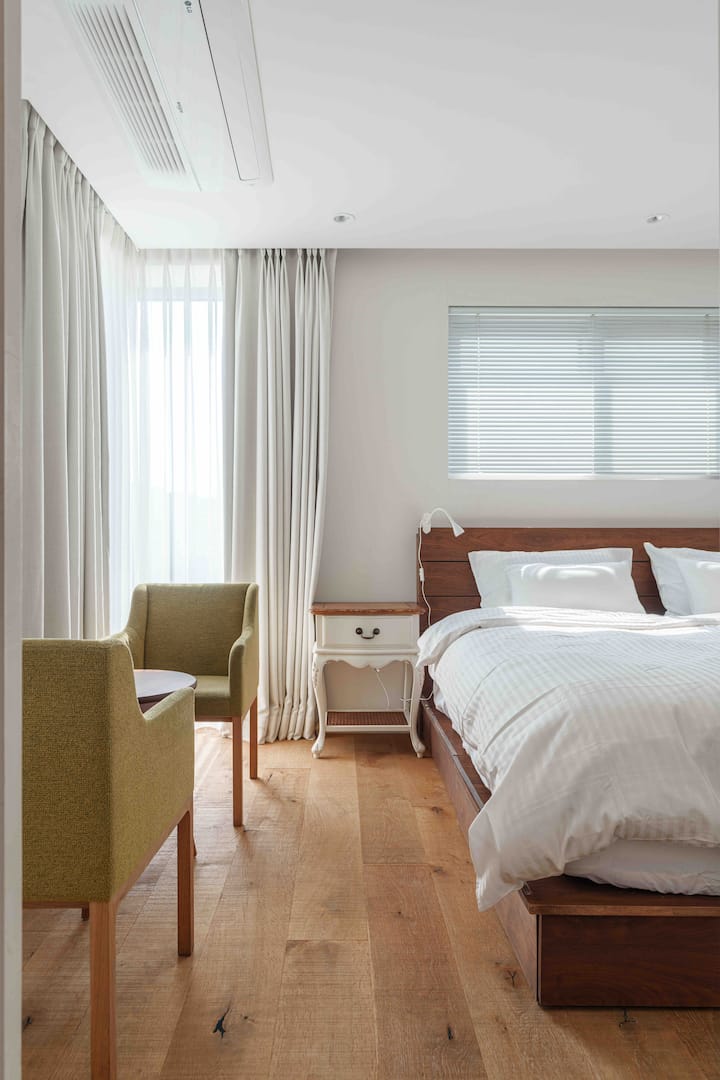 5th floor bedroom where the sun gently seeps above the solid hardwood floors with nature's grain. Enjoy a cozy retreat in a space where luxury and relaxation stay together.