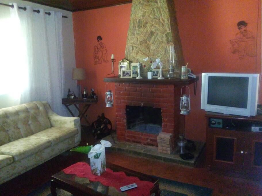 Sala com lareira dois sofás e um sendo sofá cama