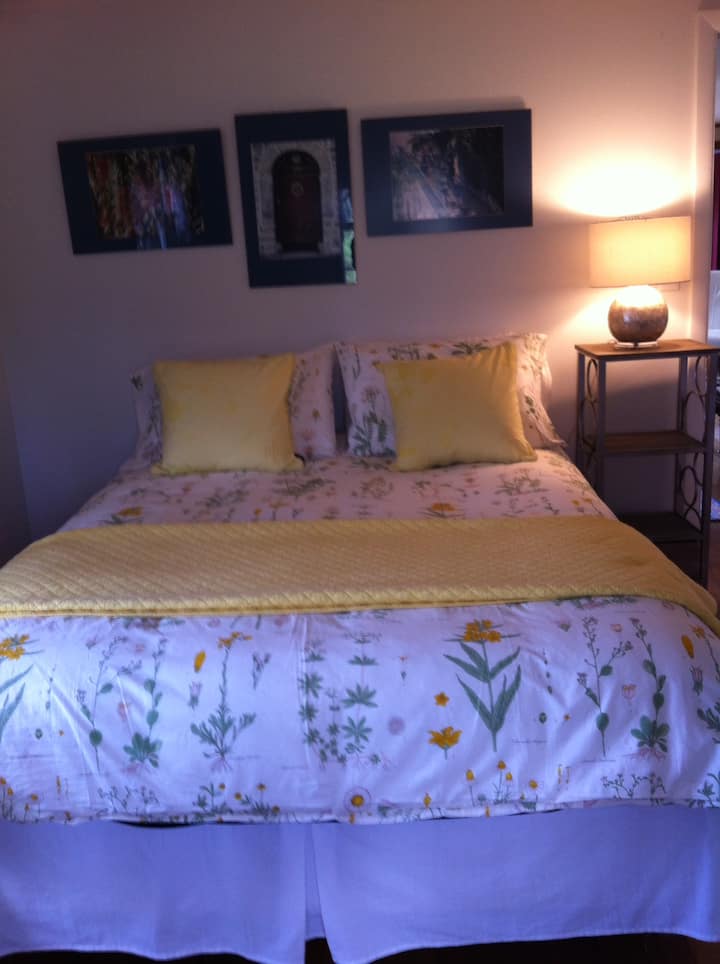 Cama queen en el dormitorio con vistas al lago