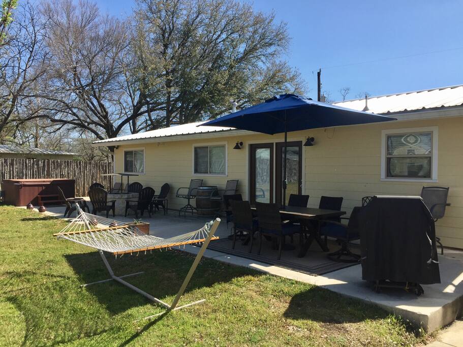 Amazing backyard setup with hot tub, grill, hammock, and a variety of seating options