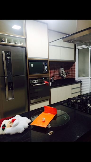 Cozinha equipada com forno elétrico, ilha cooktop, adega, torre quente e fria