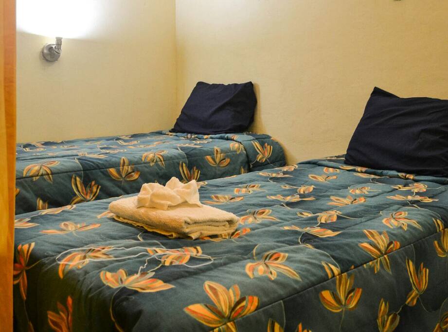 Cubiculo para 3 personas una cama matrimonial y una individual. Con baños compartidos. Y puerta corrediza