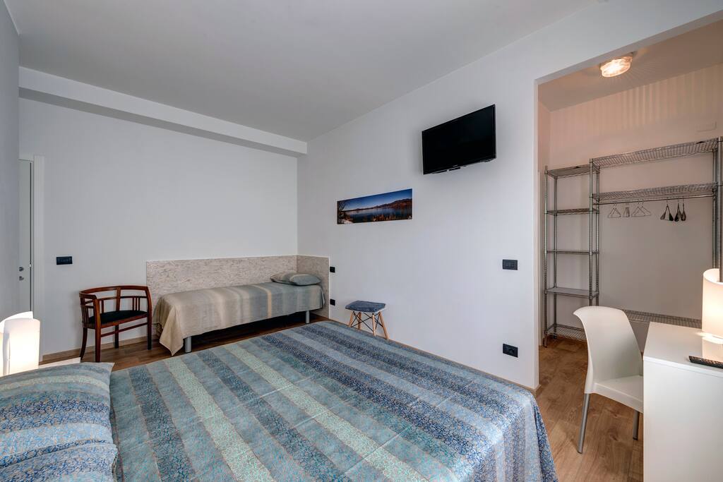 Bedroom has desk and open wardrobe