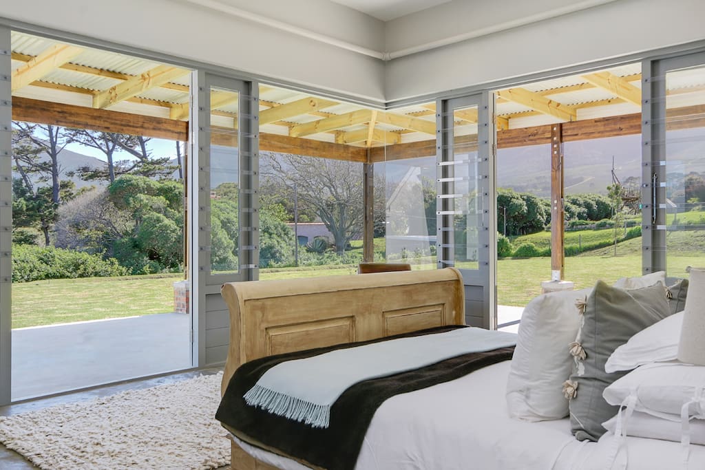 main bedroom with mountain views, doors onto the garden, dam and swimming pool, with a large en suite bathroom