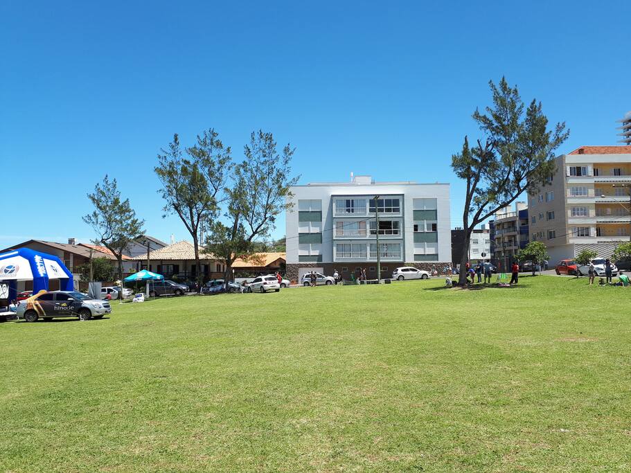 Praça em frente ao prédio toda gramada